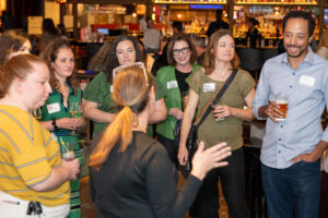 Event professionals gathered for a group site tour at Puttshack Denver, hosted by VenuHub. The group is engaged in a lively conversation during the walkthrough with Barbara Gart. Photo by All Digital Photo and Video.