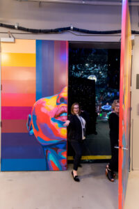 Jennifer Robinson, Director of Special Events at AEG Presents, and Dawn Williams, Founder of VenuHub, holding open the backstage door at Mission Ballroom (Denver muralist Detour’s artwork featured) Photo © Studio JK.