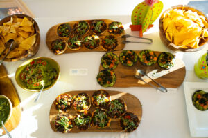 Colorful catering spread from Centro Mexican Kitchen at a Boulder event, featuring tostadas, guacamole, and tortilla chips on wooden boards.